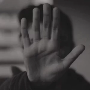 Black-and-white photo of a raised hand symbolizing victims, protection, and resistance