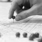 Crime Pattern Theory (Brantingham & Brantingham) Crime Pattern Theory illustration showing a hand placing a pin on a city map, symbolizing spatial crime patterns, hotspot analysis, and environmental criminology.